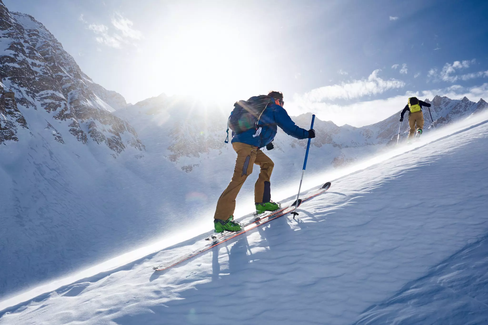 A skier heading uphill in a snowy mountainous area