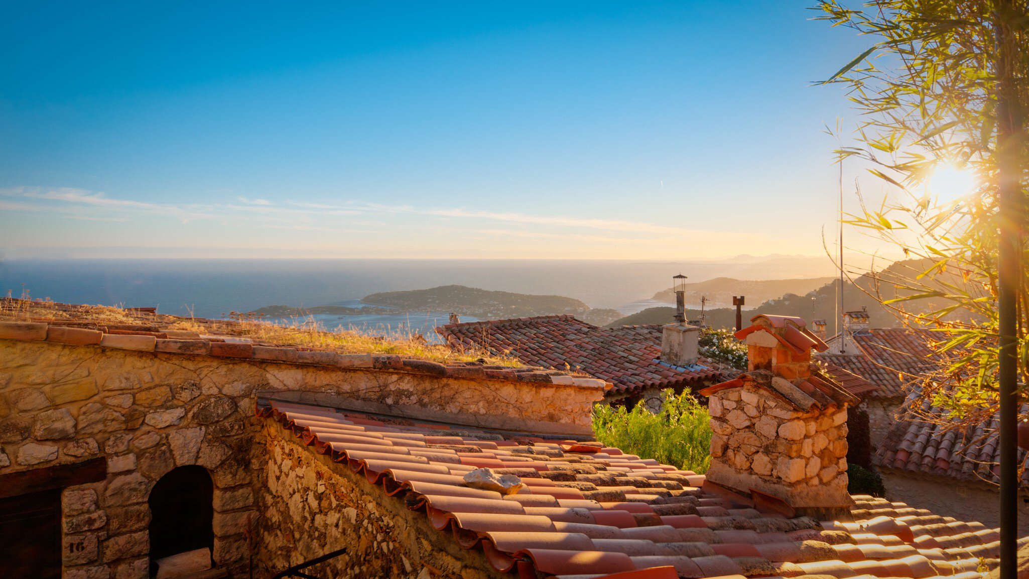 Roofs with sea in background at sunset.