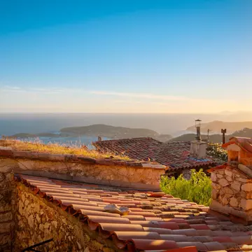 Roofs with sea in background at sunset.