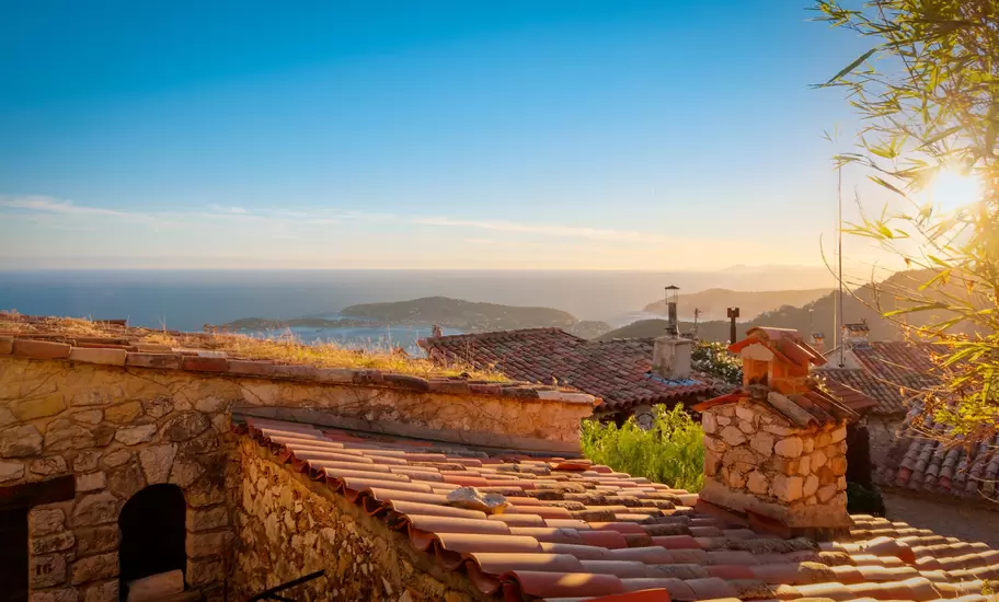 Roofs with sea in background at sunset.