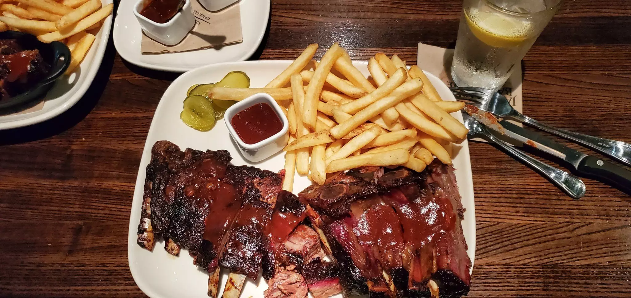 A plate of barbecue ribs, brisket, pork and chicken slathered with sauces.