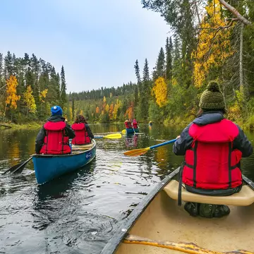 Several kayakers make their way through the water in Oulanka National Park in Finland