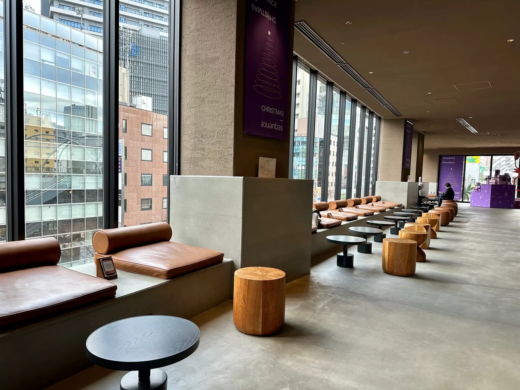 Round tables lined along large glass windows with cylindrical chairs in front of them at a hotel in Tokyo