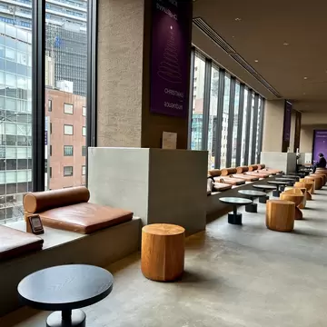 Round tables lined along large glass windows with cylindrical chairs in front of them at a hotel in Tokyo