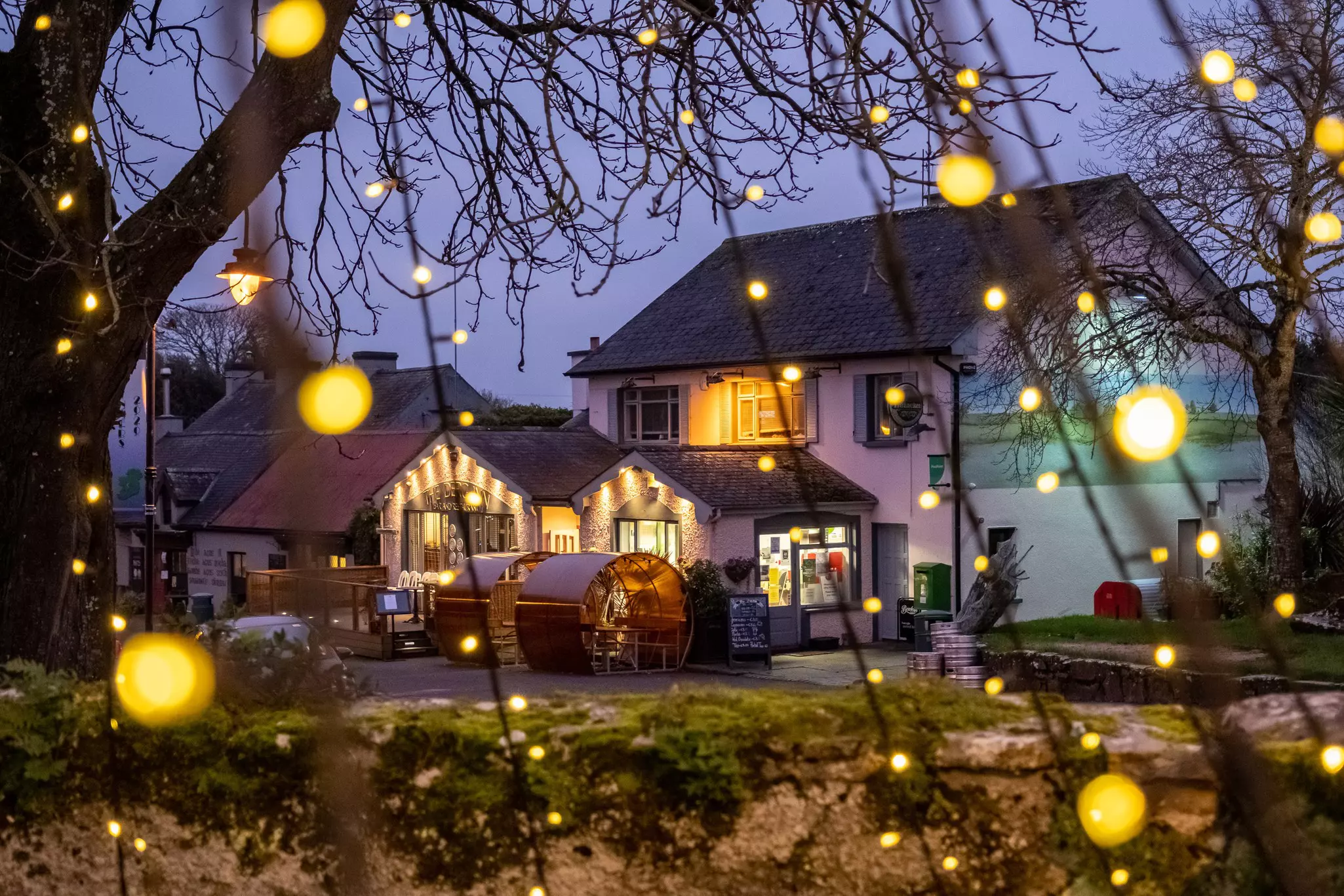 A pub at nighttime, framed by twinkling lights