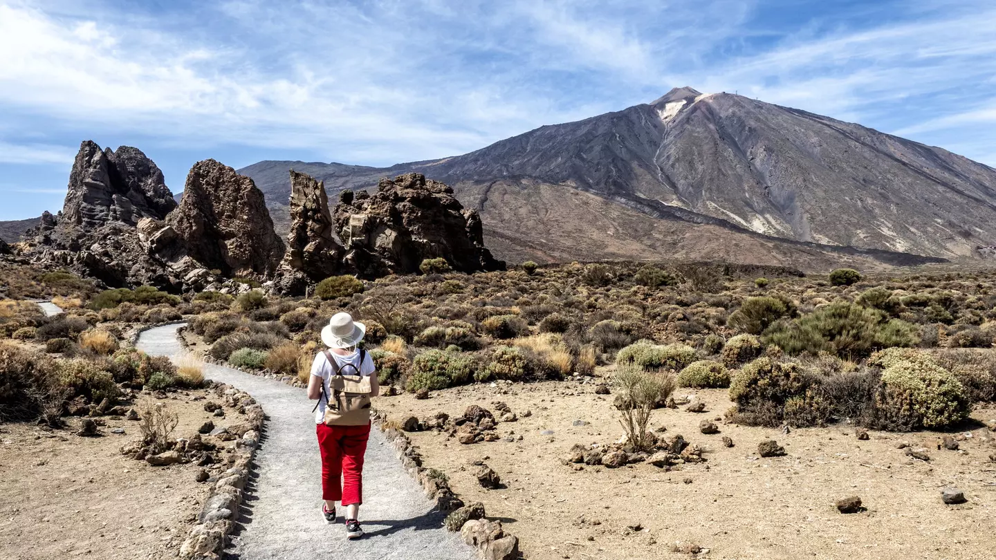 A woman hiking through a volcanic mountain landscape in Tenerife, Canary Islands