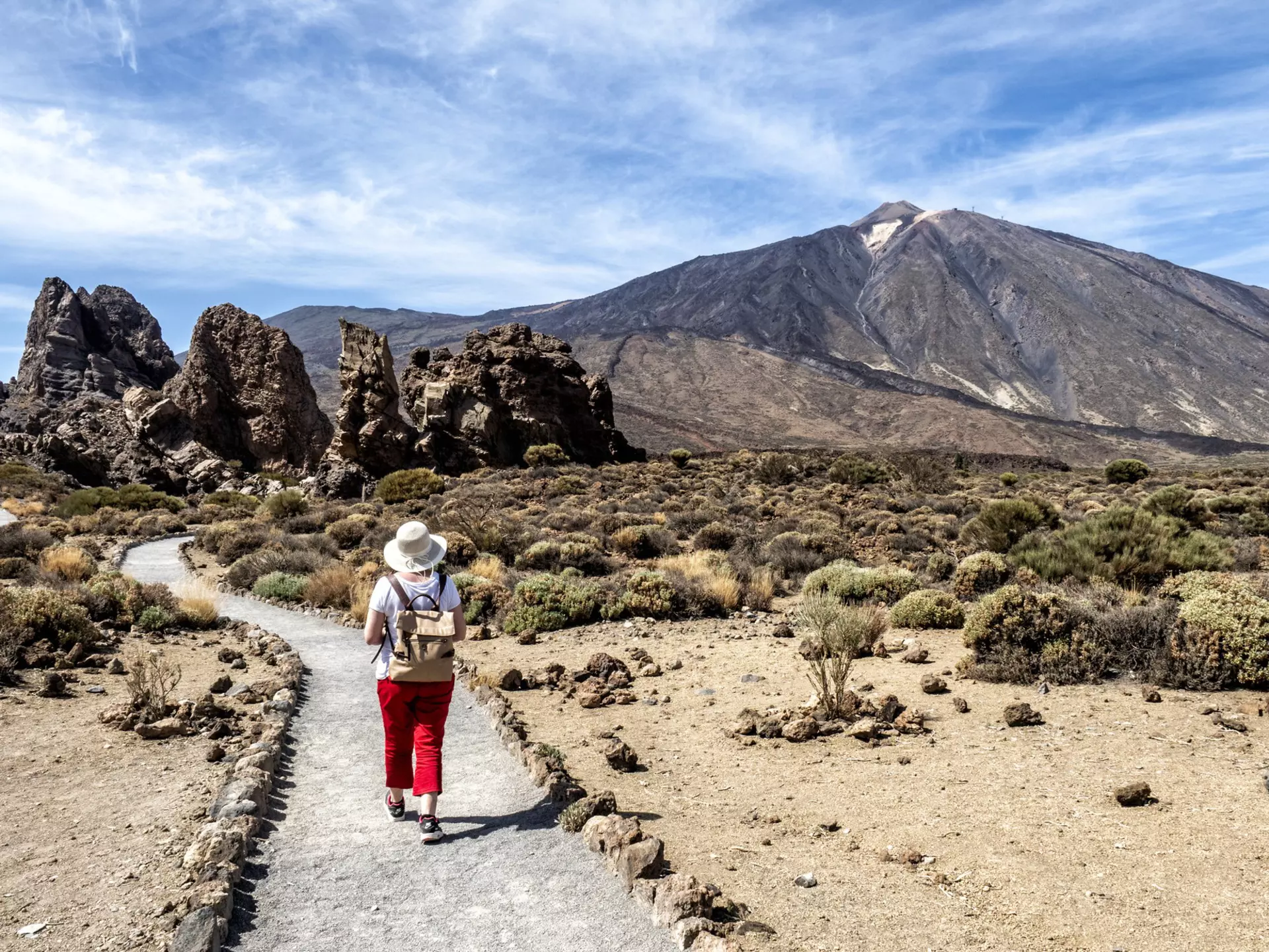 A woman hiking through a volcanic mountain landscape in Tenerife, Canary Islands