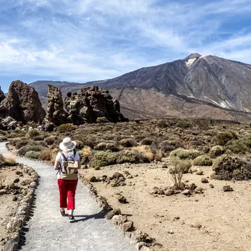 A woman hiking through a volcanic mountain landscape in Tenerife, Canary Islands