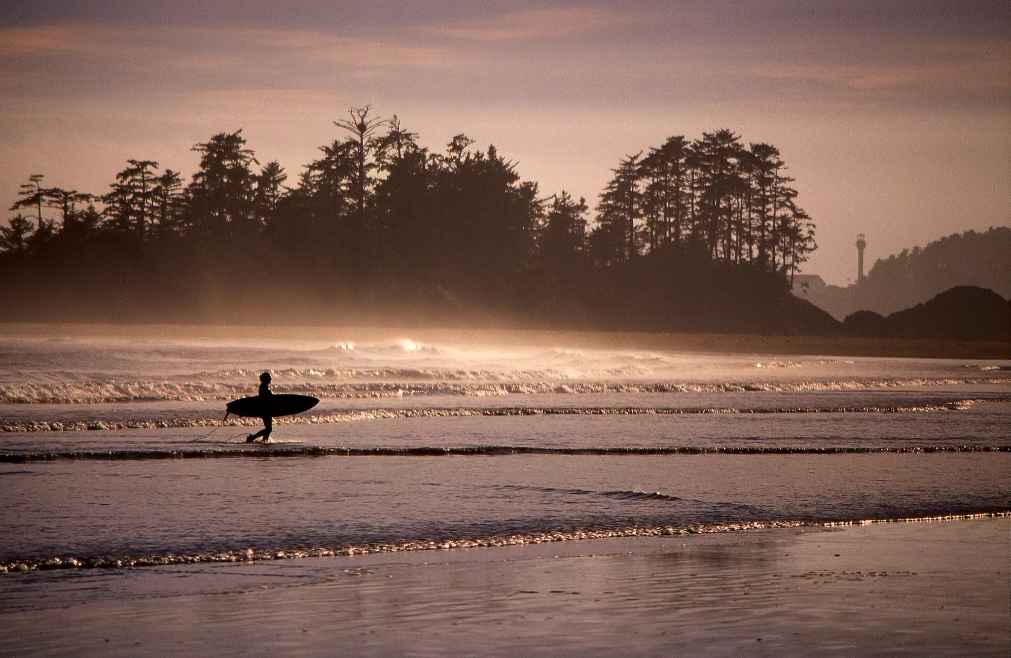 A surfer on the beach near Tofino, Canada
