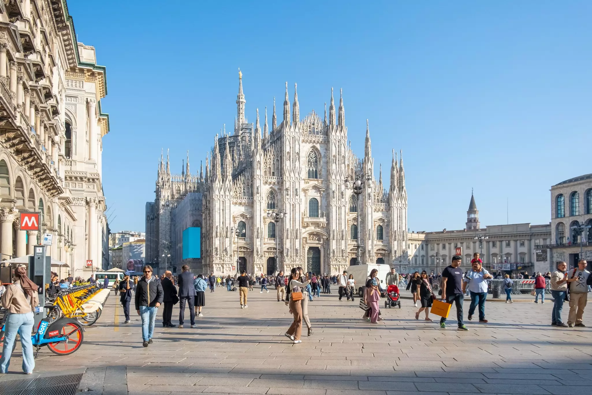 Tourists in Piazza del Duomo with Duomo di Milano with intricate Gothic architecture, in Milan, Italy.