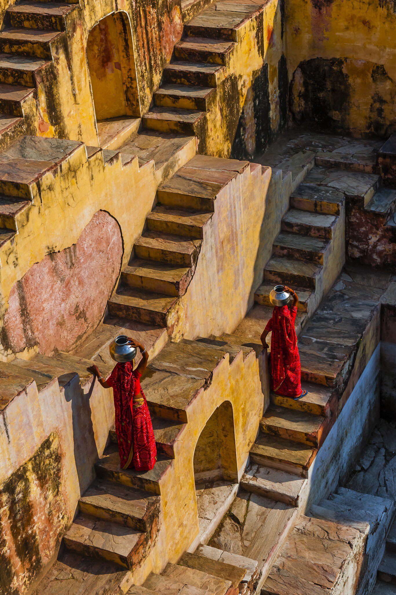 Two local women going to fetch water in Panna Meena Ka Kund step well, (baori), Amer (near Jaipur), Rajasthan, India.