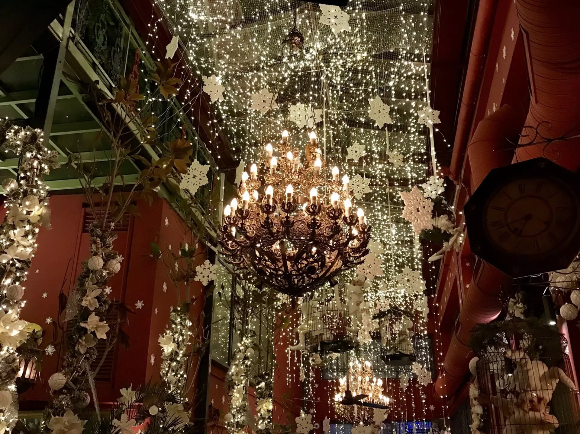 A large chandelier is covered in fake snow flakes that also hang from the ceilings at Noel Bar in Athens