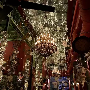 A large chandelier is covered in fake snow flakes that also hang from the ceilings at Noel Bar in Athens