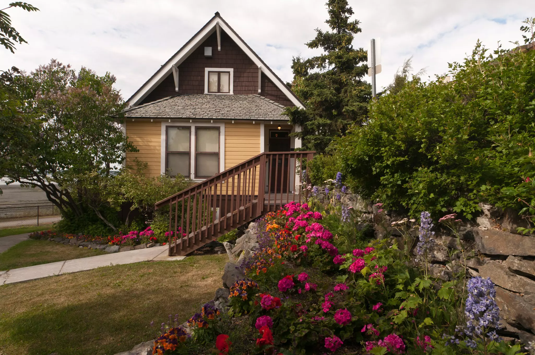 The Oscar Andersen House in Anchorage, Alaska, with flowers in the garden in front.