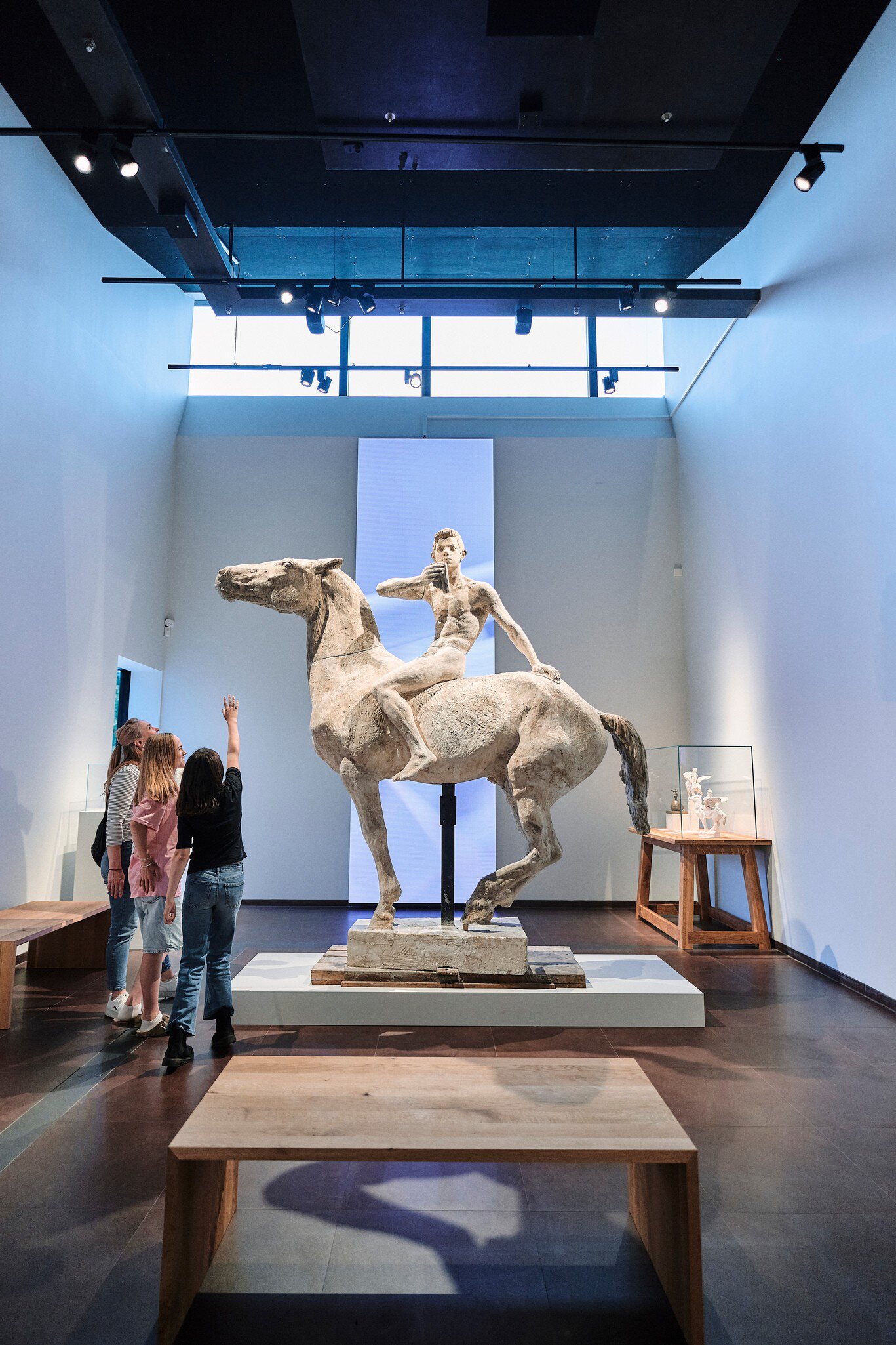 Interior of TID Museum in Odense, Denmark. Group of visitors looking at a sculpture.