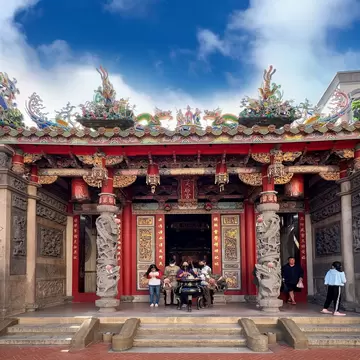 The facade of Cijin Tianhou Temple in Kaohsiung, Taiwan with intricate carvings in the columns on roof.