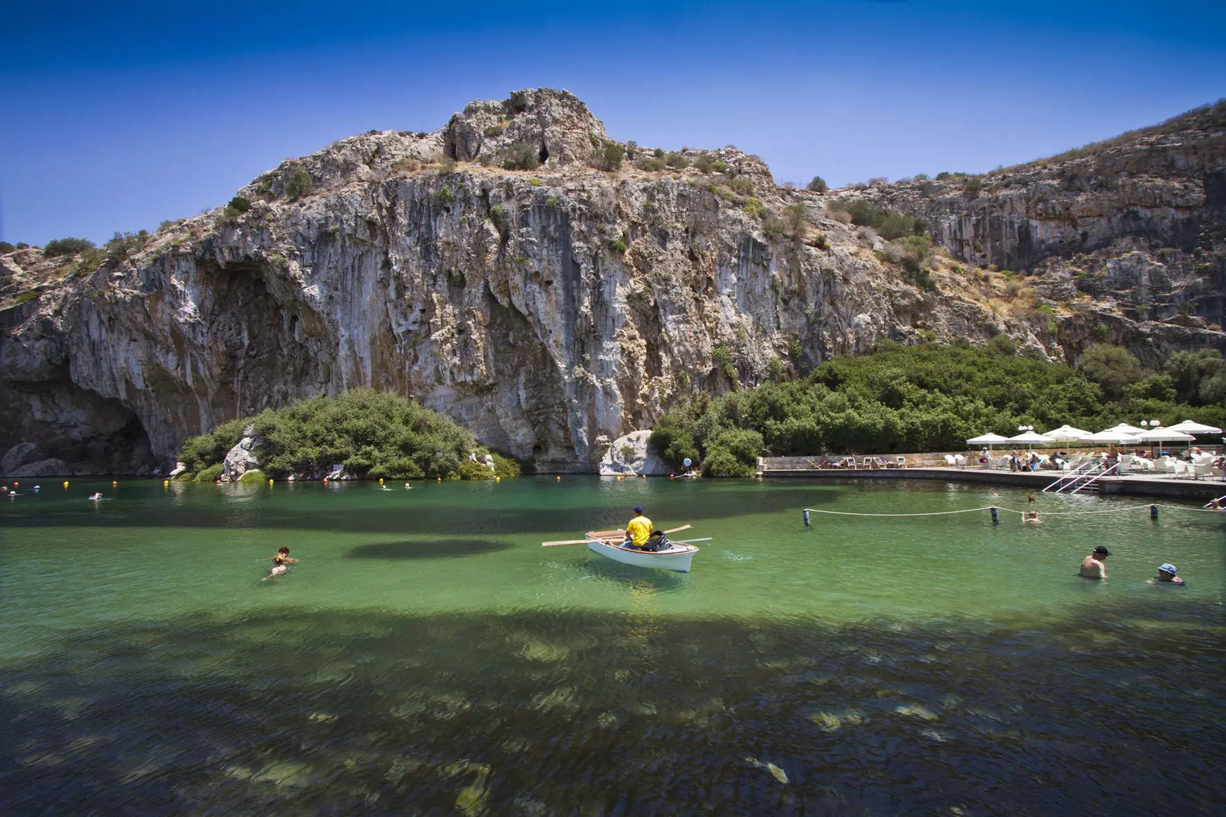  People swimming and in boats at Vouliagmeni Lake, south of Athens.