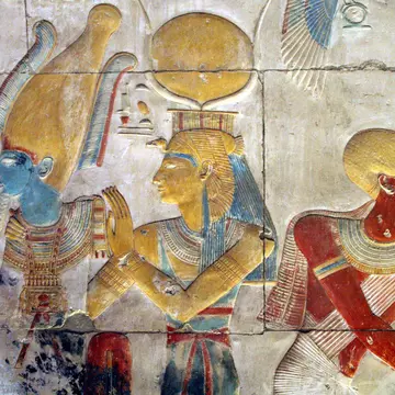 Painted bas relief of Osiris and Isis wearing the headdress of Hathor at the Temple of Seti I.