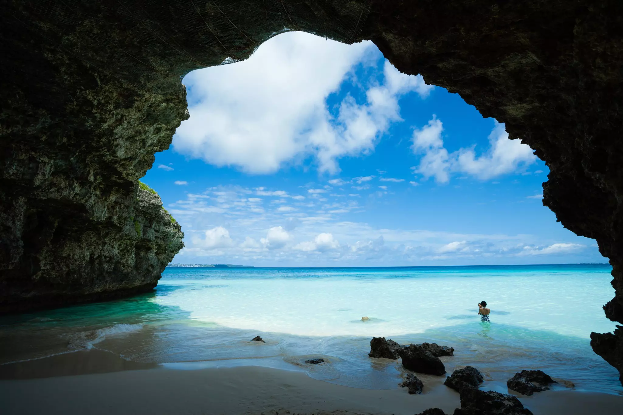 Tropical paradise beach with a limestone cave arch and clear turquoise water, Sunayama beach, Miyako island, Okinawa.
