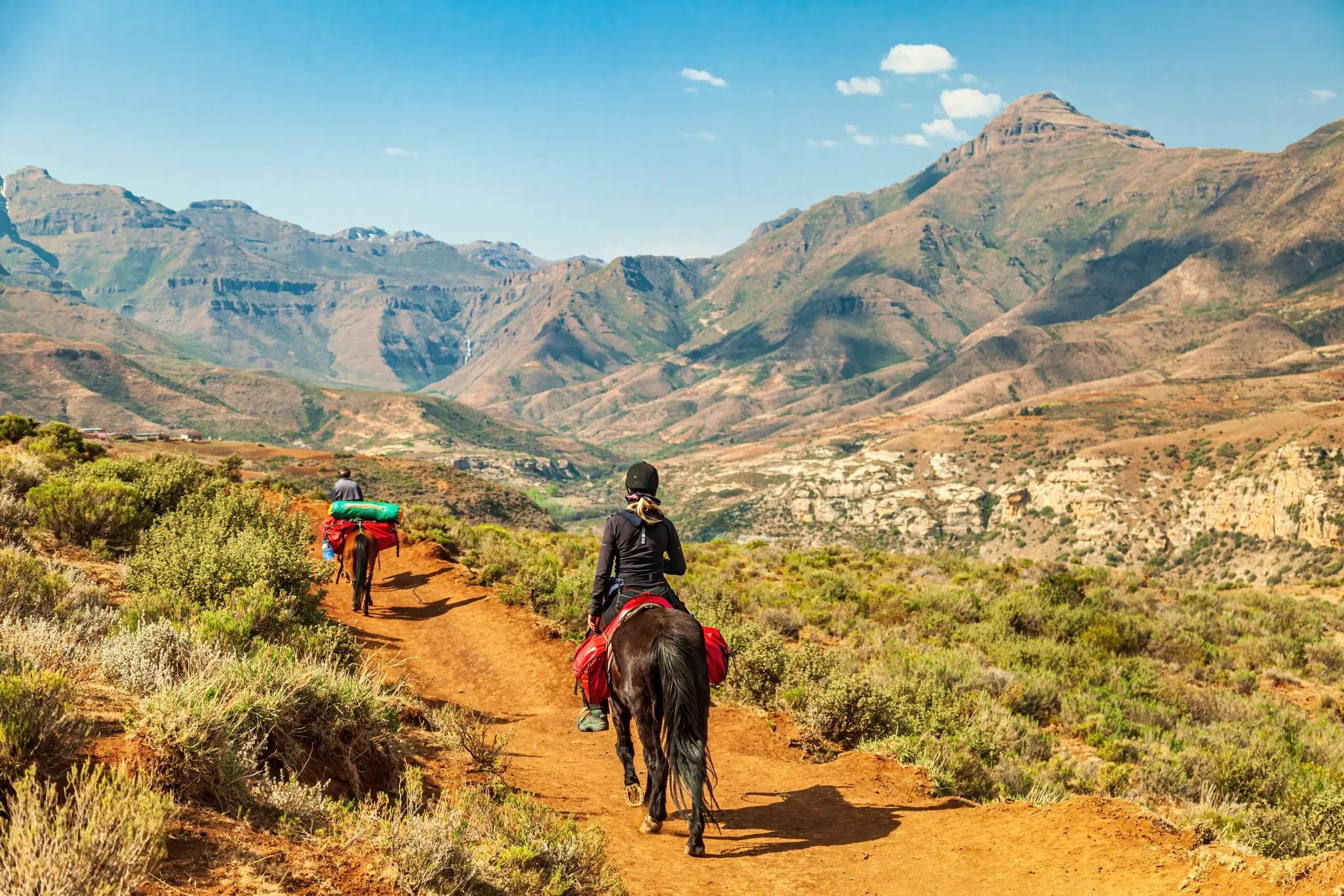 Female tourist riding on a Basotho Poney in Lesotho, Africa.