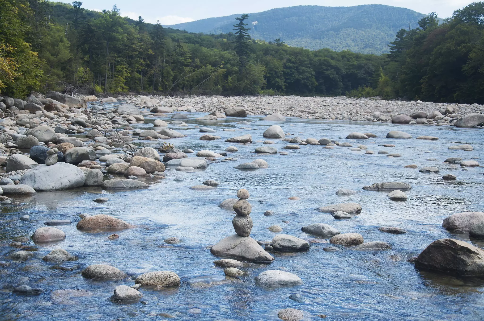 A stack of rocks in the middle of a river.