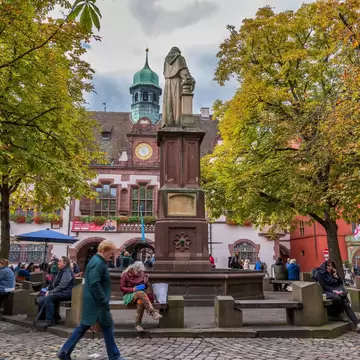 Berthold Schwarz Brunnenand monument and fountain on Rathausplatz square and Neues Rathaus (New Town Hall) in Freiburg, Breisgau, Germany. 