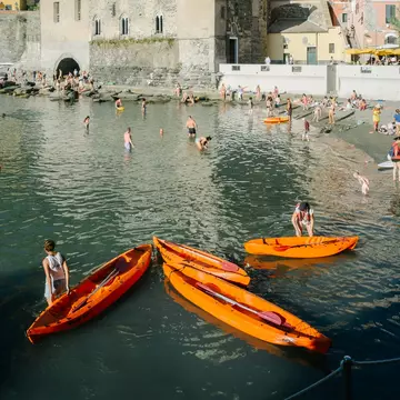 People swim in the harbor of Vernazza, a tourist town in the Cinque Terre.