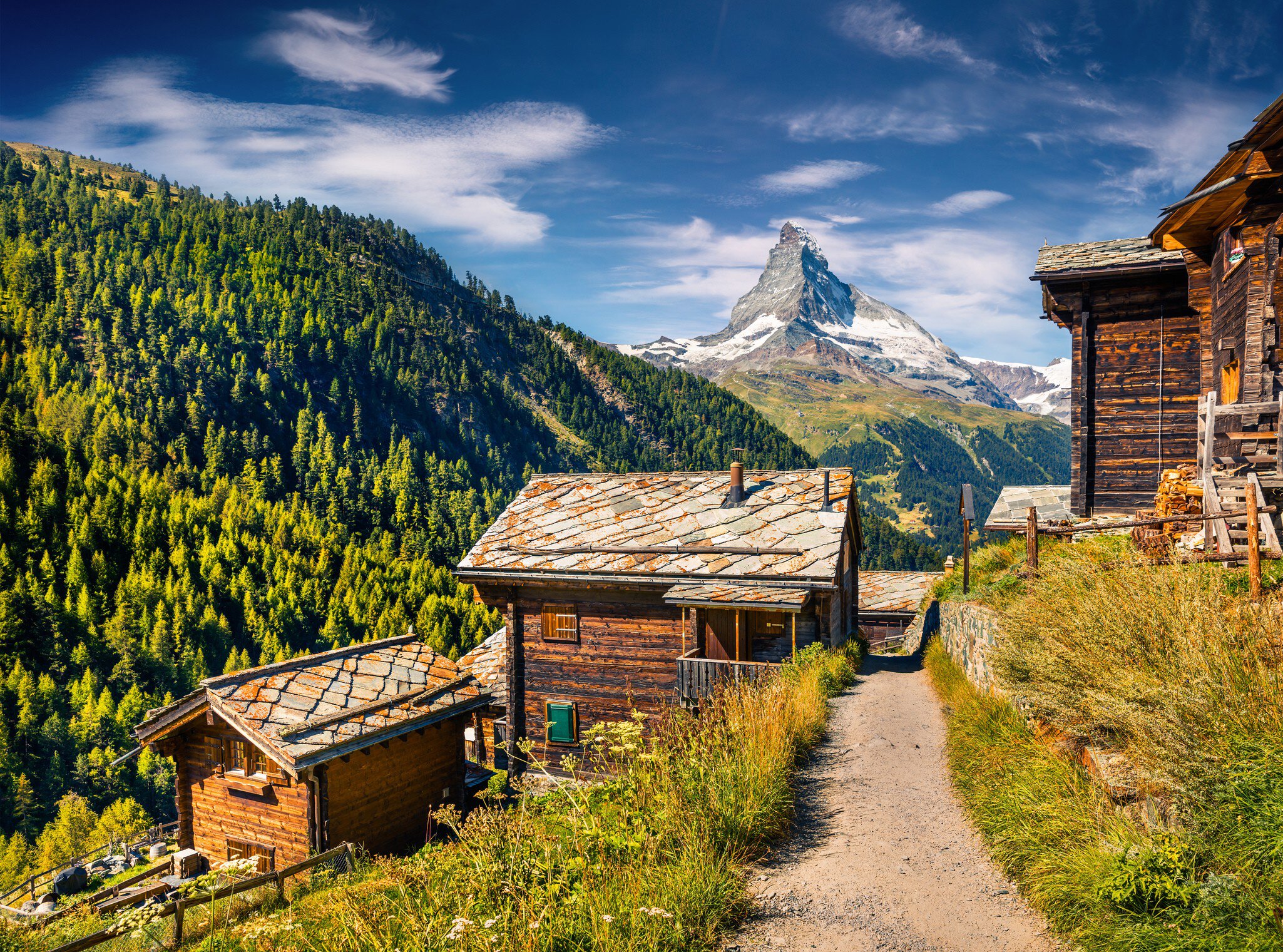Sunny summer morning in Zermatt village with Matterhorn (Monte Cervino, Mont Cervin) peak on backgroud. Beautiful outdoor scene in  Swiss Alps, Valais canton, Switzerland, Europe.