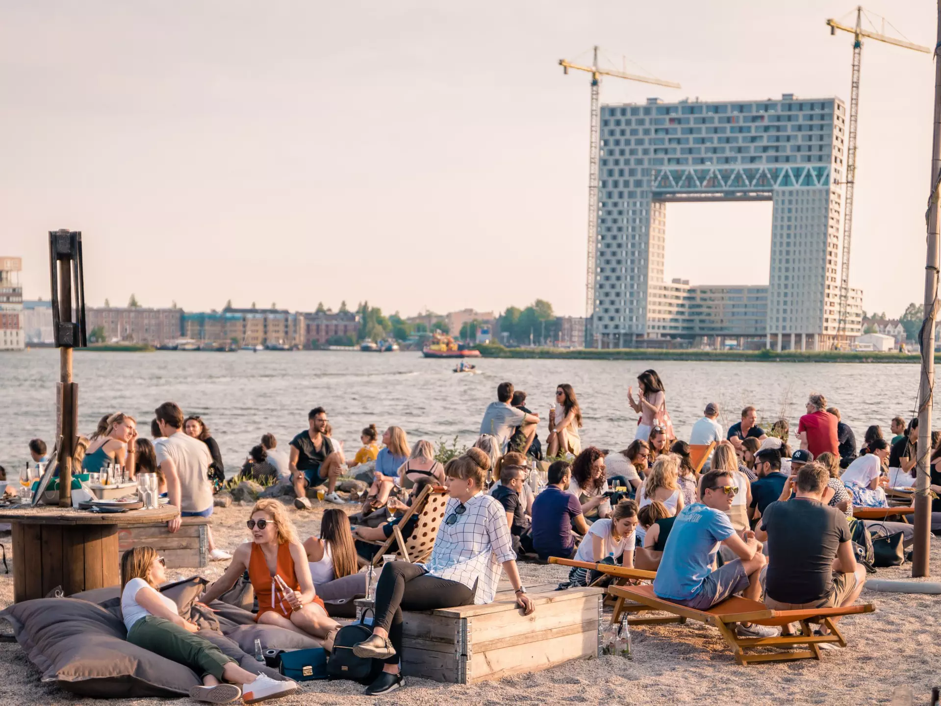 Patrons lounge on a beach at art festival Kinetisch Noord, held at NDSM Wharf. fokke baarssen / Shutterstock