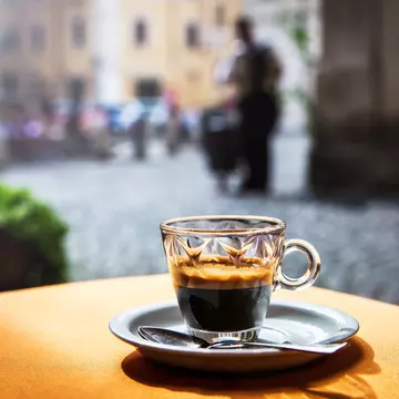 Cup of hot black coffee espresso on a table in a cafe