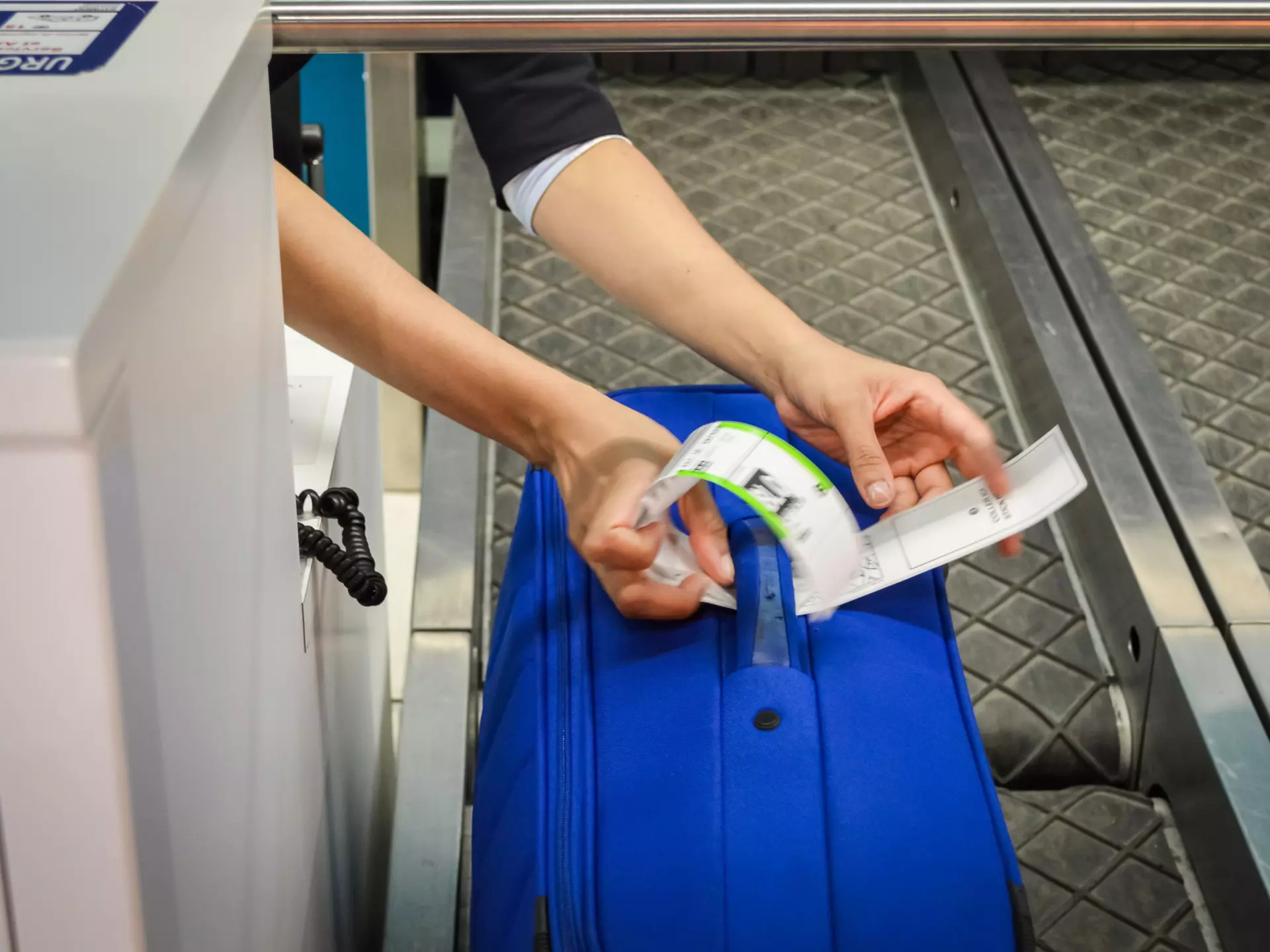 Check-in employee attaches a luggage tag