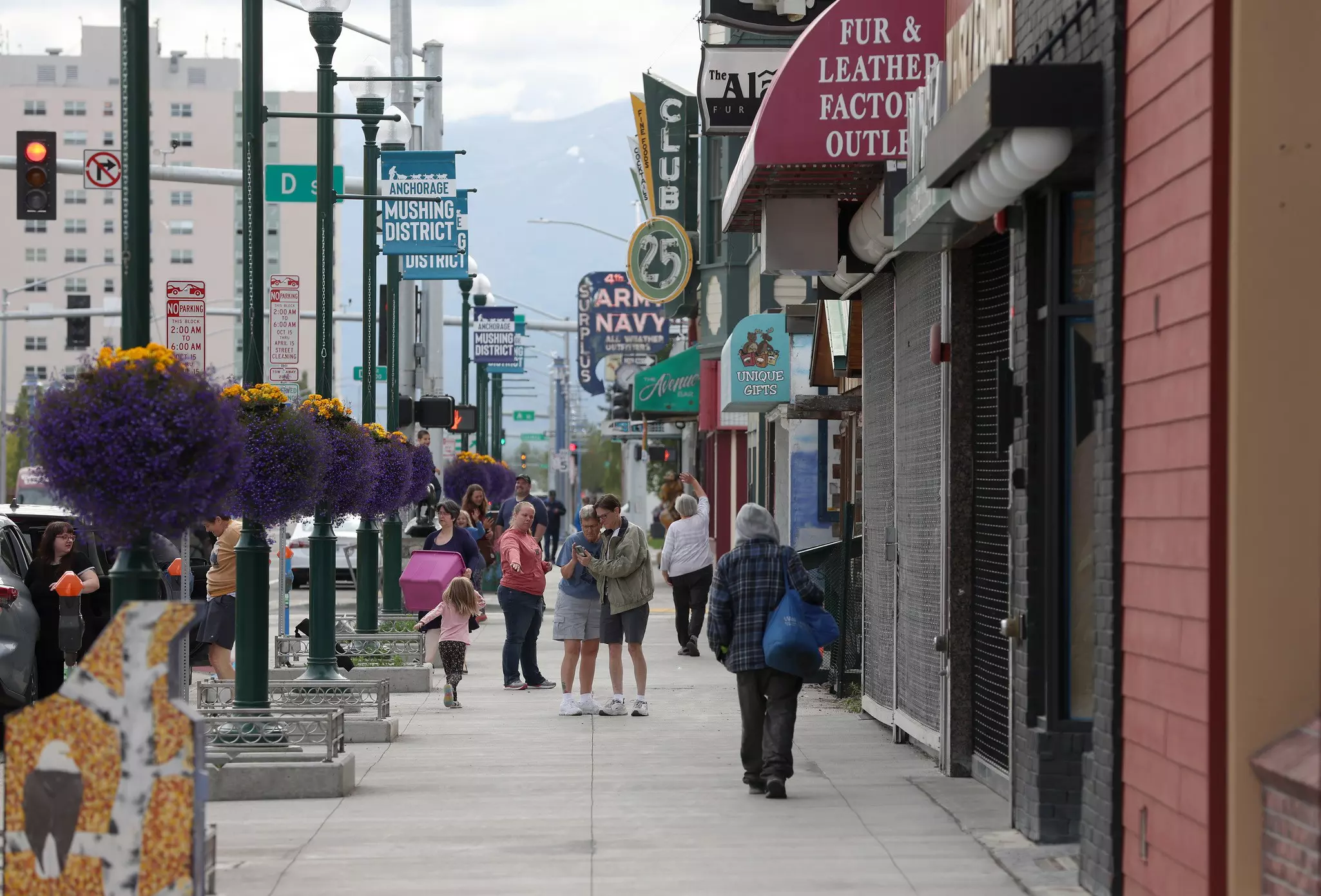 People walk past retail stores in the downtown Mushing district in summer, Anchorage, Alaska
