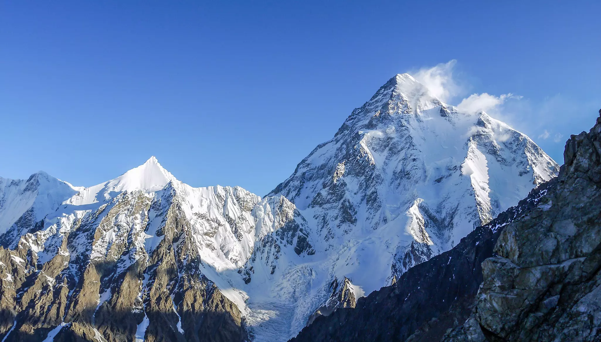 A snow-capped mountain peak among a range of mountains