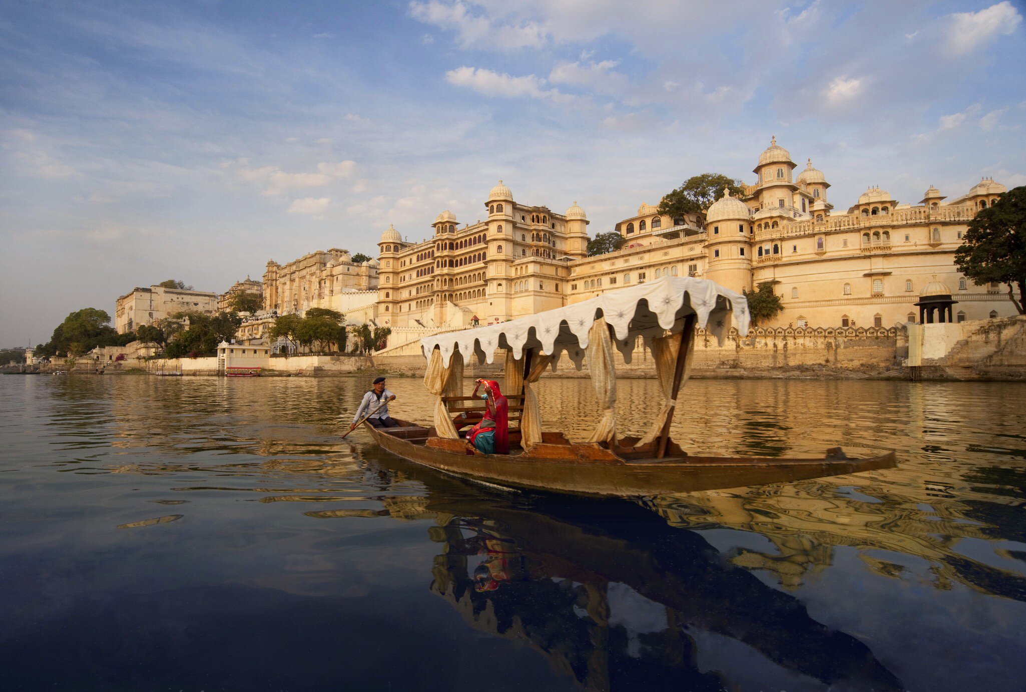 Woman on boat on Lake Pichola beside City Palace. Rajasthan, India.