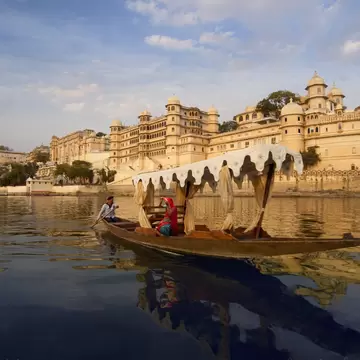 Woman on boat on Lake Pichola beside City Palace. Rajasthan, India.