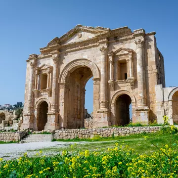 Arch of Hadrian at the roman ruins of Jerash, Jordan. Front view on a sunny day with blue sky. It features some unconventional, possibly Nabataean, architectural features, such as acanthus bases.; Shutterstock ID 1673108263;