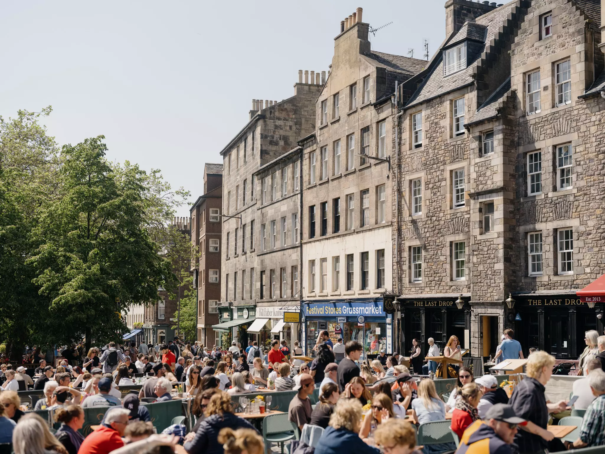 Crowds sitting outside pubs in Edinburgh's Old Town