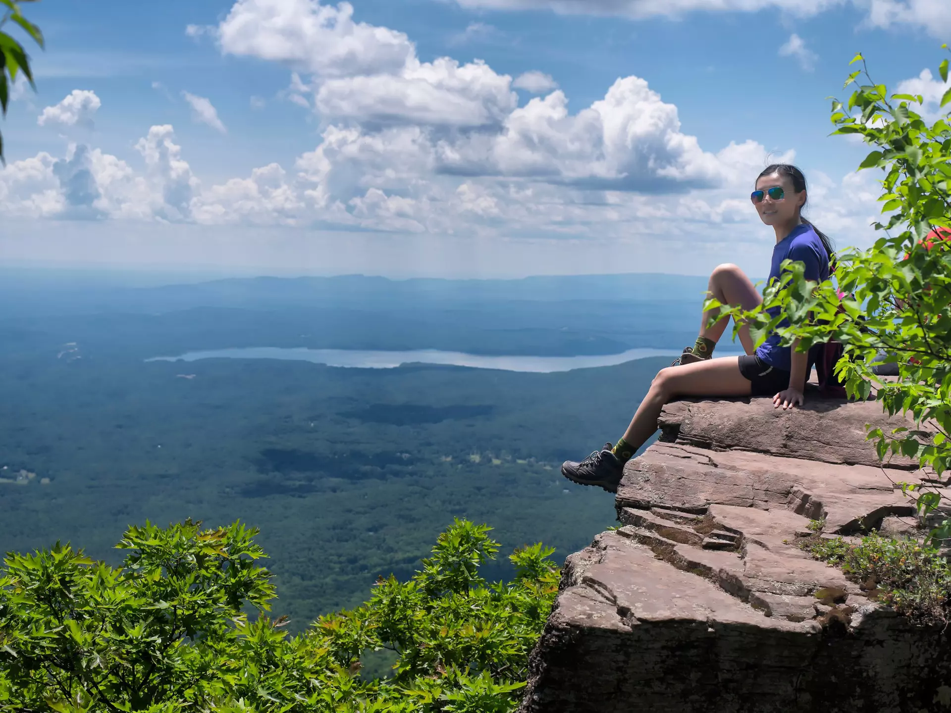 woman sitting on the edge of a cliff on top of overlook mountain in the catskills in Woodstock New York.jpg