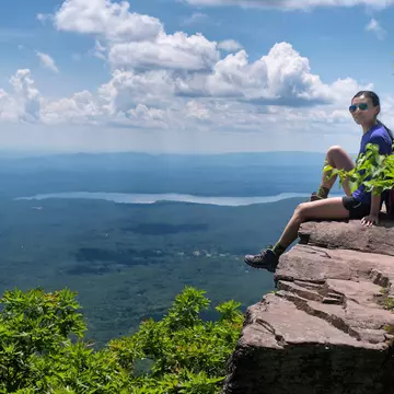 woman sitting on the edge of a cliff on top of overlook mountain in the catskills in Woodstock New York.jpg