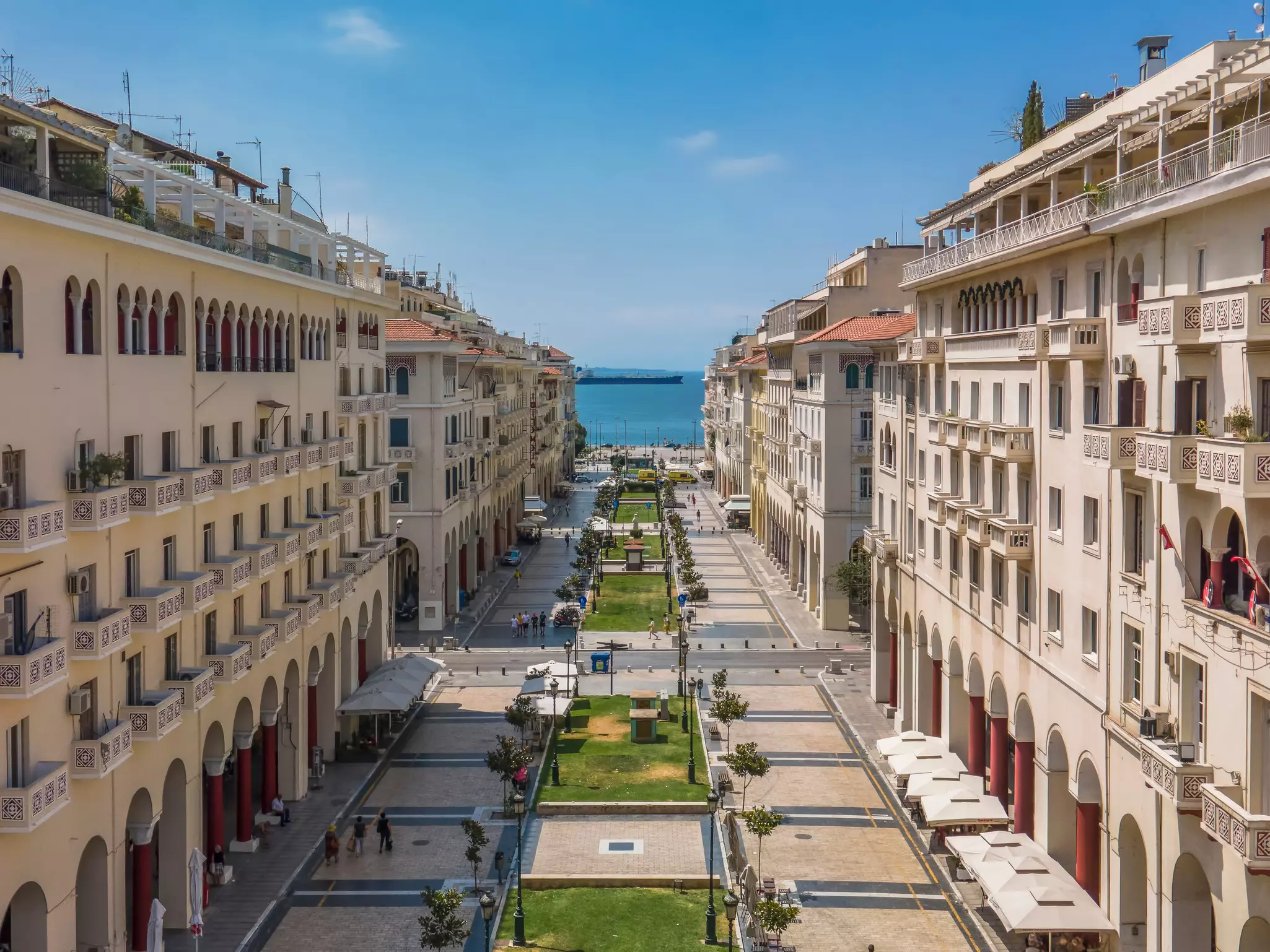 Aerial drone view of pedestrian area of a central square with low-rise earth-toned buildings on a sunny day