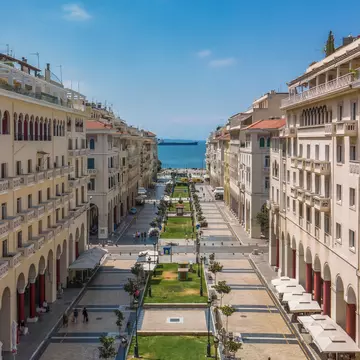 Aerial drone view of pedestrian area of a central square with low-rise earth-toned buildings on a sunny day