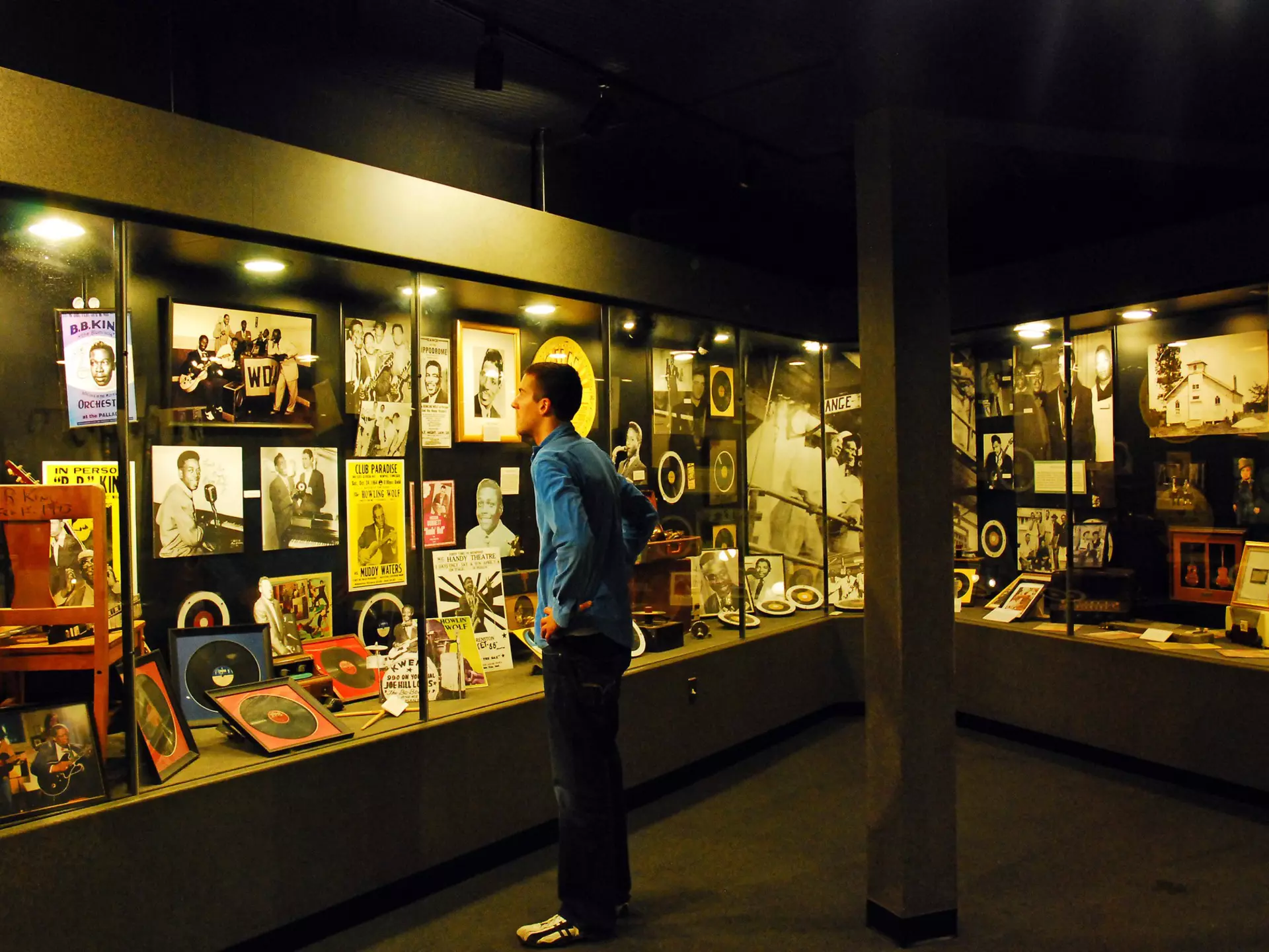 A man looks at old records, posters and photos encased in a large display at Sun Studios in Memphis, TN.