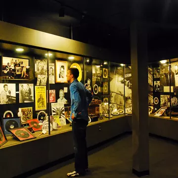A man looks at old records, posters and photos encased in a large display at Sun Studios in Memphis, TN.