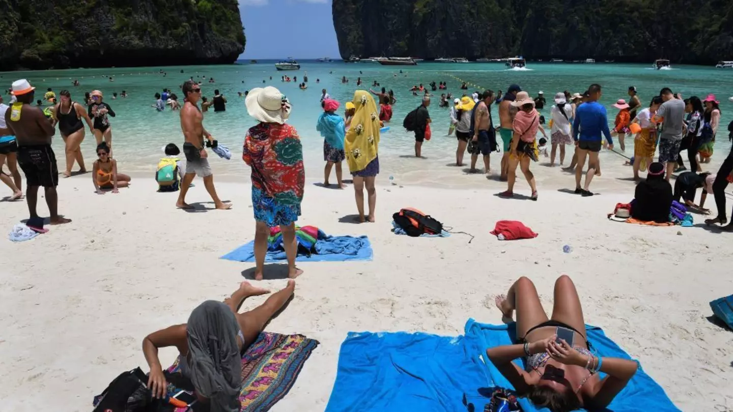 Tourists sunbathing and walking on Maya Bay