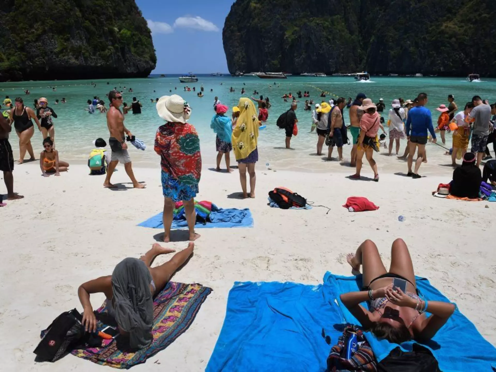 Tourists sunbathing and walking on Maya Bay