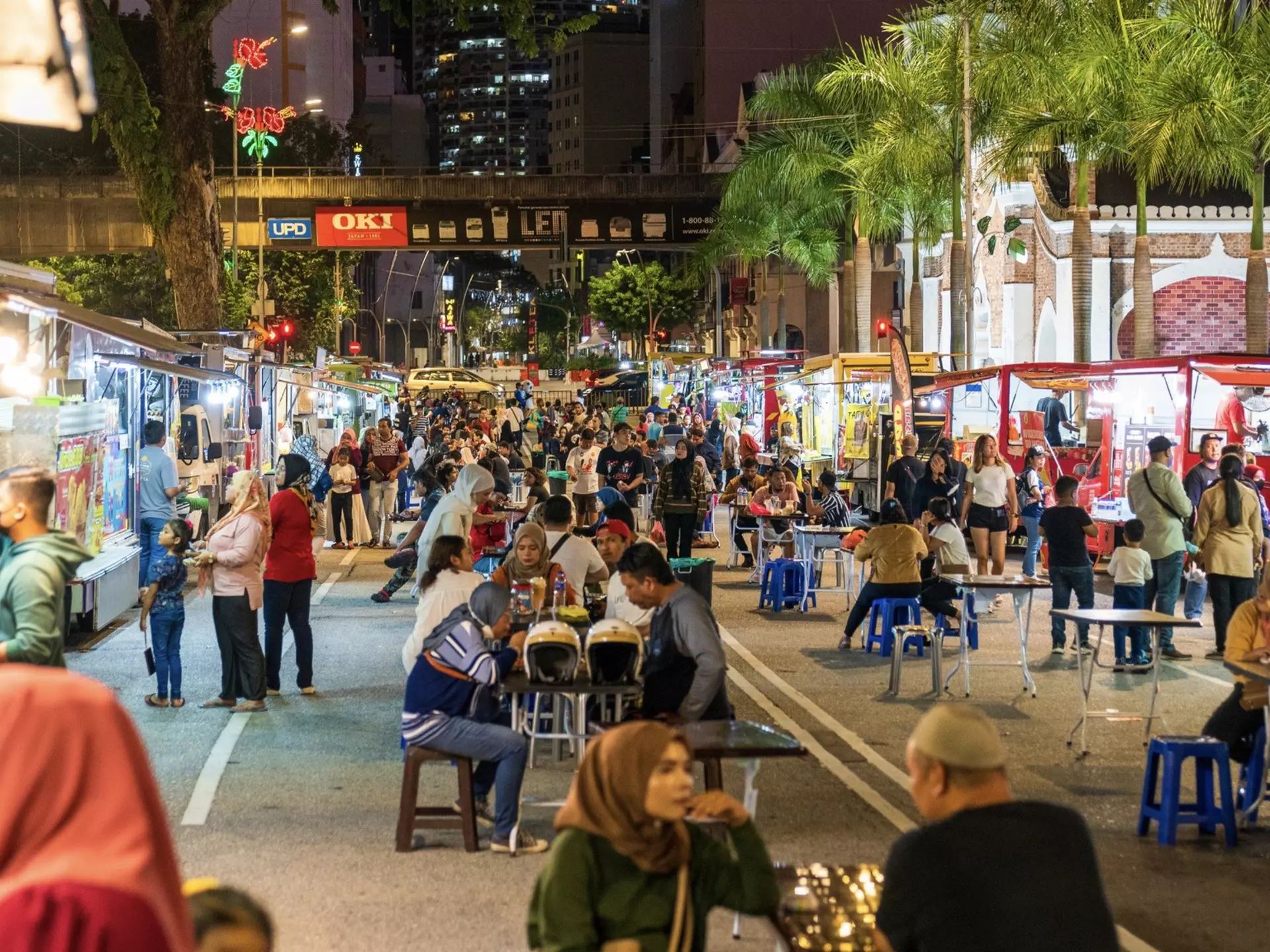 People sitting at tables in a street market