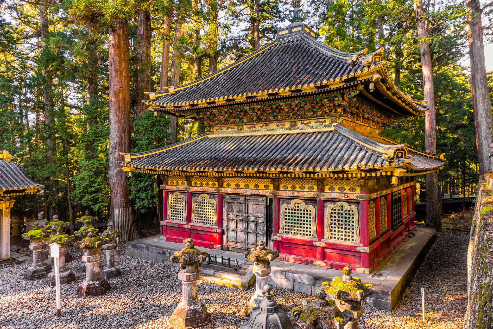 A beautiful temple in a wooded area is pictured at sunrise.