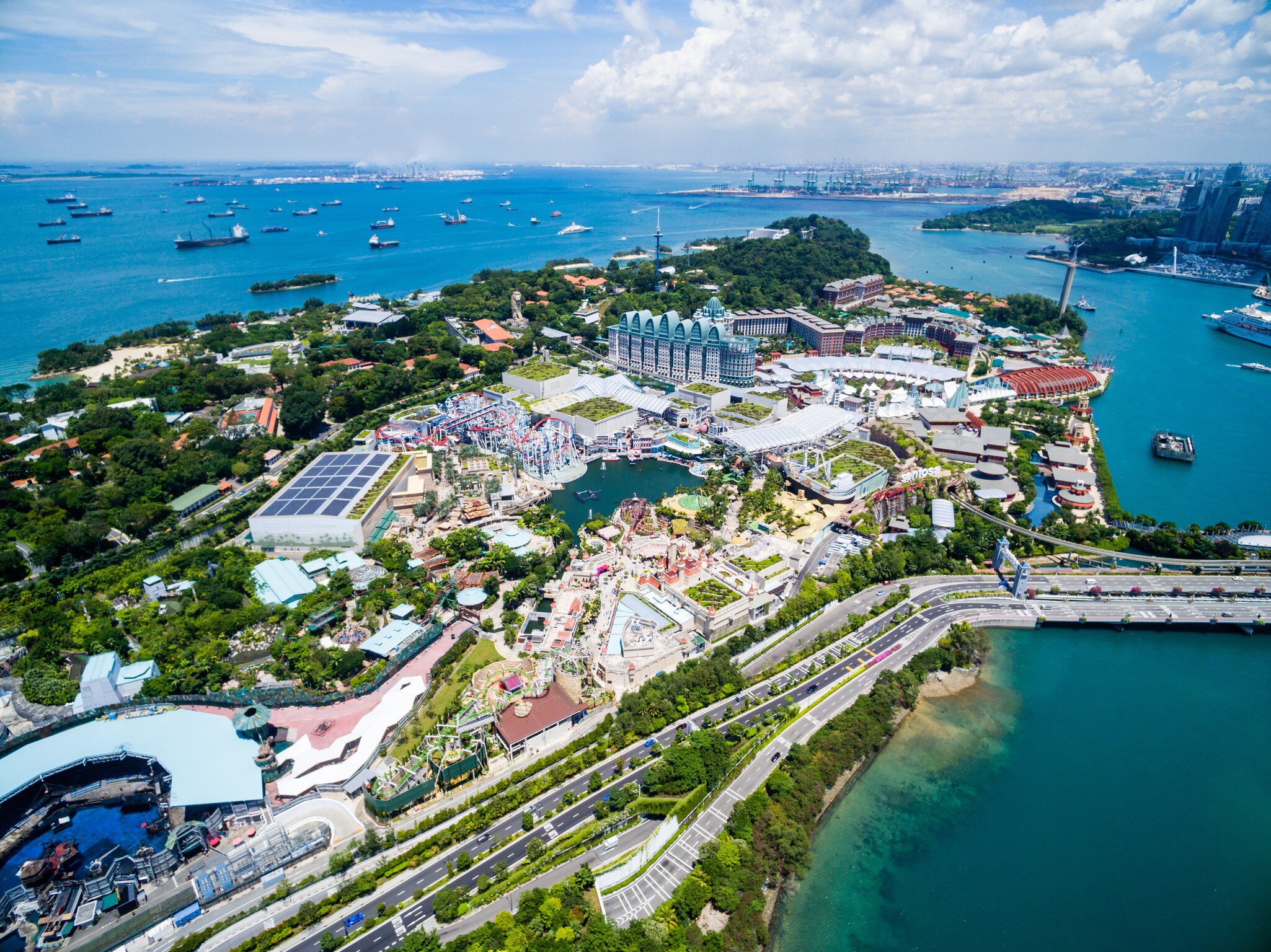 Aerial view of a resort island's theme park, marina and harbour.