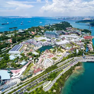 Aerial view of a resort island's theme park, marina and harbour.