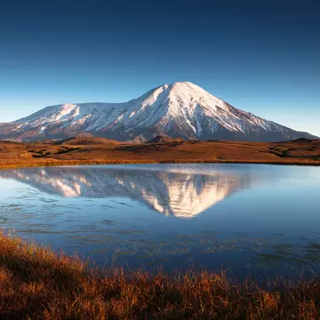 Snowcapped mountain with lake in foreground, Kamchatka, Russia